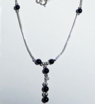Halskette aus Silber mit kleinen Kugeln und schwarzen Steinen